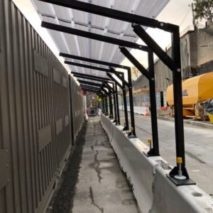 Walkway cover connecting to anchors on Jersey Barriers 2 e1568344263123